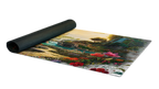 A rectangular mat with a detailed landscape print, partially unrolled from a black rolled-up end